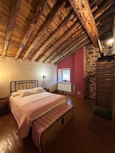 ナバレドンダ・デ・グレドスにあるCasa Rural La Casa de Piedraの木製の天井が特徴のベッドルーム1室(大型ベッド1台付)