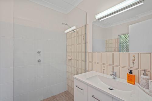 a white bathroom with a sink and a shower at Delightful 3-Bed Home Minutes from Avoca Beach in Avoca Beach