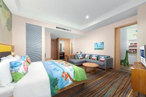 a bedroom with a bed and a living room at Holiday Inn Express Emei Mountain by IHG in Emeishan