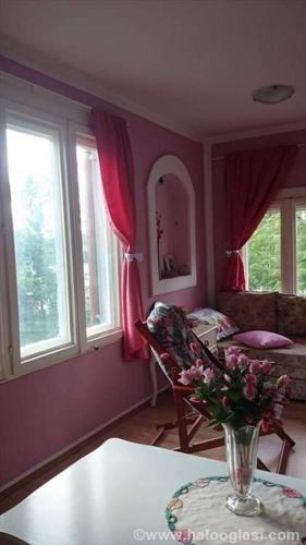una sala de estar con un jarrón de flores sobre una mesa en Kuća na Drini, en Luke