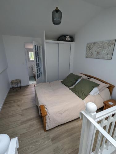 une chambre avec un grand lit et un escalier dans l'établissement Charmant appartement avec jardin au calme, à Châteauneuf