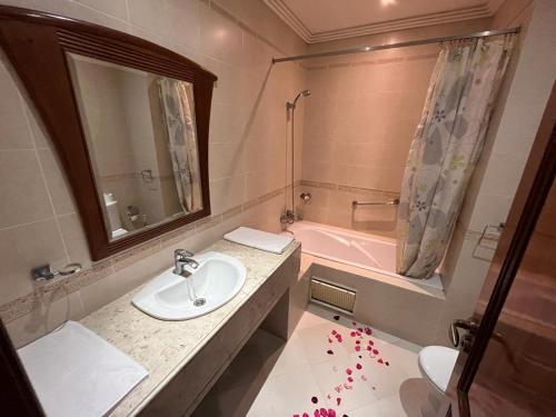 a bathroom with a sink and a pink bath tub at Hotel Malta in Meknès