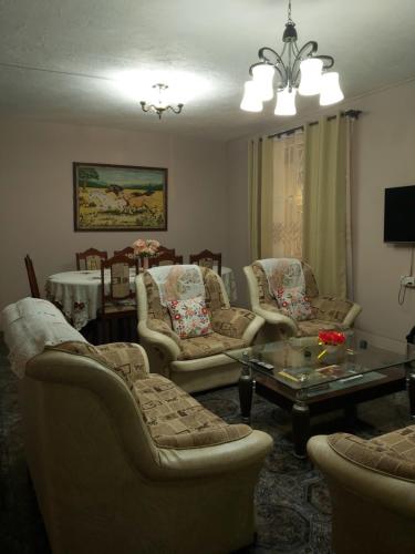 uma sala de estar com sofás e uma mesa em Yuti Homestay em Quatre Bornes