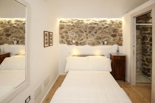 a bedroom with a white bed and a mirror at B&B Domos Mi & Ro in Castelsardo