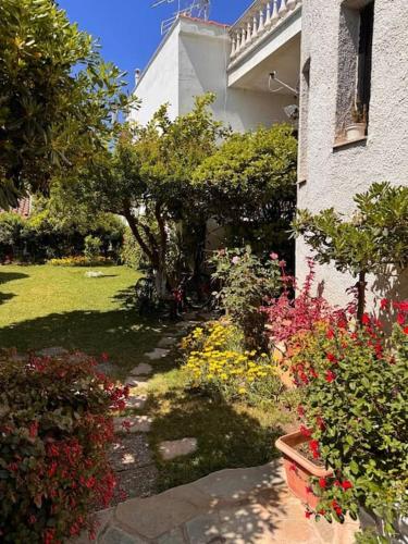 a garden with flowers next to a house at Family Woodland Oasis VIPGreece in Kírinthos