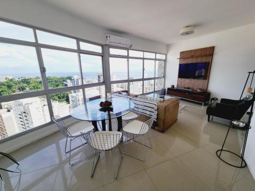comedor con mesa y sillas en una habitación con ventanas en Luxury Surround Sea View Apartment, en Salvador
