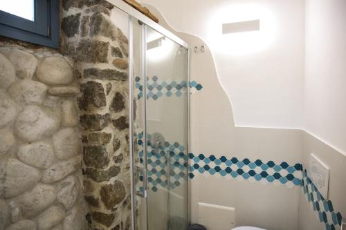 a bathroom with a shower with blue and white tiles at B&B Domos Mi & Ro in Castelsardo
