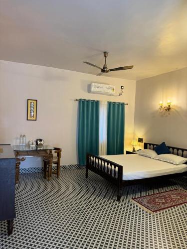 a bedroom with a large bed and a table at SANTINIKETAN RETREAT, Bolpur in Shānti Niketan