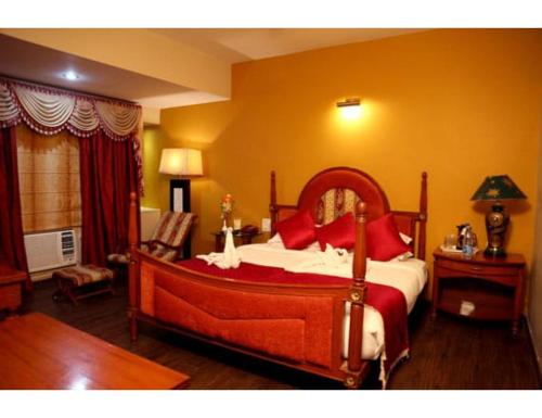 a bedroom with a large bed with red pillows at Hotel Ans International, Raigarh, in Raigarh