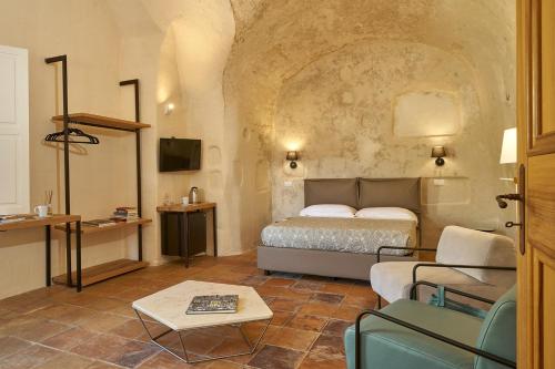 ein Schlafzimmer mit einem Bett, einem Sofa und einem Tisch in der Unterkunft Ai Terrazzini in Matera