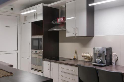 a kitchen with white cabinets and a coffee maker on a counter at Apartmani Vesić in Tivat