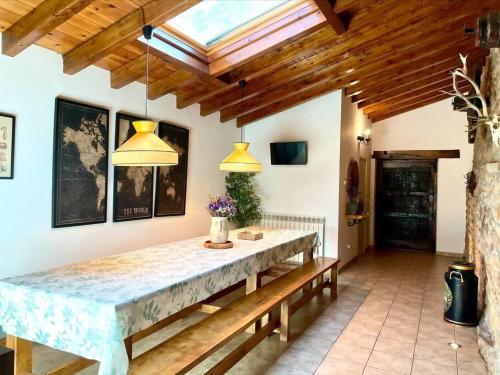 une salle à manger avec une grande table et deux lumières dans l'établissement El currillo preciosa casa rural al lado cabarceno, à Argomilla