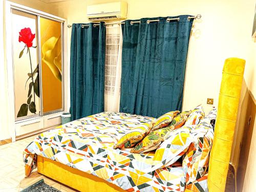 a bedroom with a bed with a colorful comforter at Maryluxe Stays in Accra