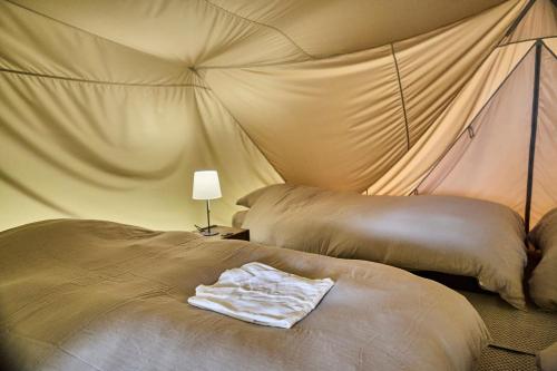 a bedroom with two beds in a tent at Snow Peak YAKEI SUITE ABURAYAMA FUKUOKA in Fukuoka