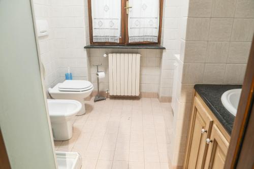 La petite salle de bains est pourvue de toilettes et d'un lavabo. dans l'établissement La Dimora di Nonno Piero, à Manta