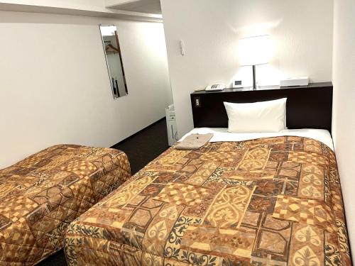 ein Hotelzimmer mit 2 Betten in einem Zimmer in der Unterkunft Hotel Tokeidai in Sapporo