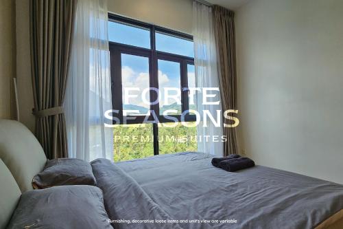 a bed in a room with a large window at Enclave Nature Suites @ Bukit Tinggi in Bentong