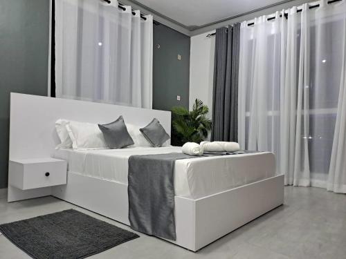 um quarto com uma cama branca e uma grande janela em Nyali Luxury em Mombaça