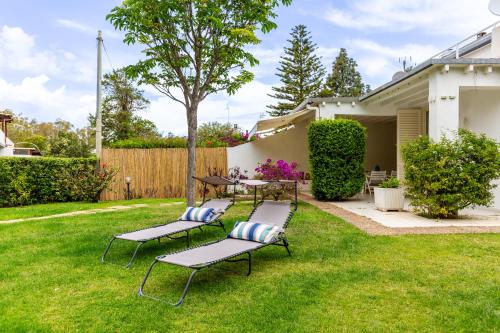 a group of chairs and tables in a yard at Villa Buganvillea near the beach in Maracalagonis