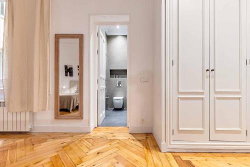 an empty white room with a mirror and a hallway at Apartamento Retiro Place II en Madrid in Madrid