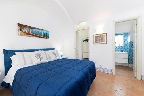 a bedroom with a blue bed and a bathroom at Apartment Stella Maris in Capri