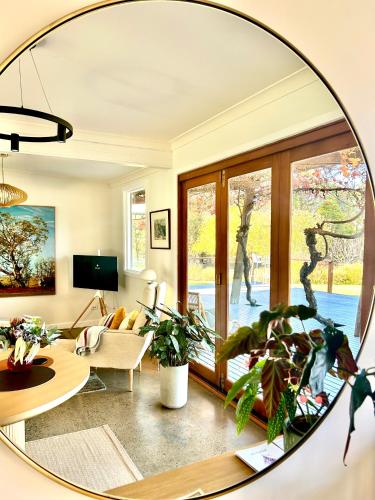 a living room with a large mirror on the wall at Alluca Villa McLaren Vale Vineyard Escape in Blewitts Springs