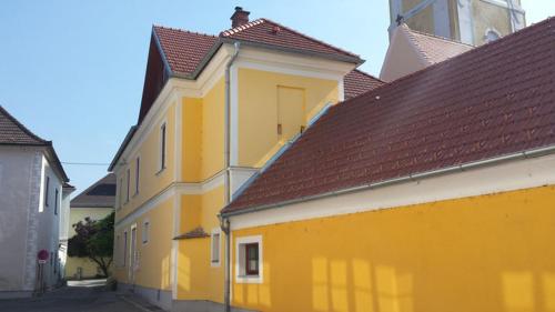 un edificio giallo con tetti marroni su una strada di Wachau - Angenehm ruhiges Zimmer 6 a Mautern an der Donau