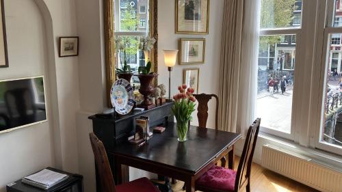 uma mesa de jantar com um vaso de flores em Canal View B&B Amsterdam em Amsterdã