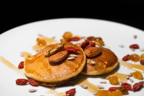 two pancakes with nuts and raisins on a white plate at Alva Valley Hotel in Oliveira do Hospital