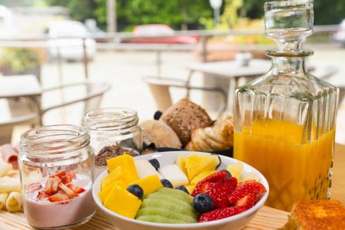 a table with a bowl of fruit and a bottle of juice at Alva Valley Hotel in Oliveira do Hospital