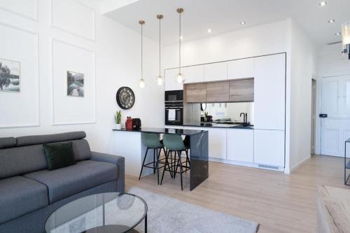 a living room with a couch and a kitchen at Monte Carlo Border - Luxury cosy and modern flat in Beausoleil