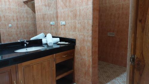 a bathroom with a sink and a shower at Hôtel La Belle Etoile in Labuan Bajo