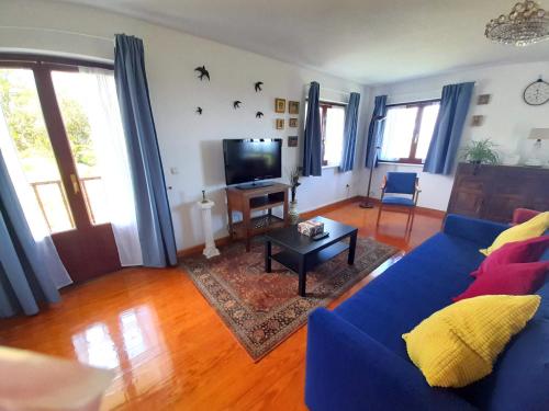 sala de estar con sofá azul y TV en VIVIENDA VACACIONAL LA RITANA, en Sardalla