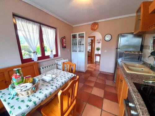 una cucina con tavolo e una sala da pranzo di VIVIENDA VACACIONAL LA RITANA a Sardalla