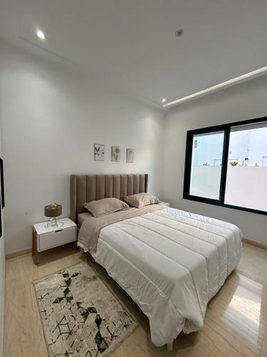 Un dormitorio con una cama grande y una ventana en joli appartement a jardin de Carthage en Túnez