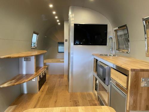 eine Küche mit einem weißen Kühlschrank und einem TV an der Wand in der Unterkunft The Silver Spirit in Gildingwells
