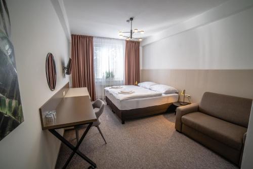 a hotel room with a bed and a couch at Hotelový Dům in Olomouc