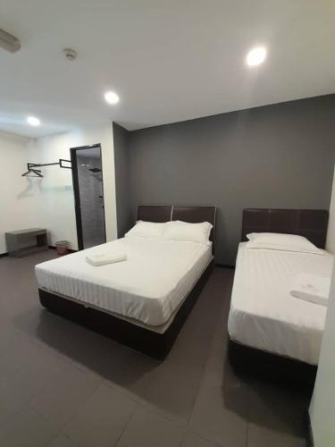 een slaapkamer met 2 bedden en witte lakens bij Sogo Hotel l in Kampung Patau Patau Dua
