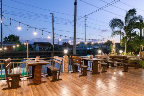 a row of tables and benches on a deck at night at Golden Foyer Suvarnabhumi Airport Hotel in Lat Krabang