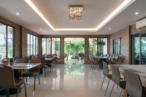 een restaurant met tafels en stoelen en een kroonluchter bij Golden Foyer Suvarnabhumi Airport Hotel in Lat Krabang