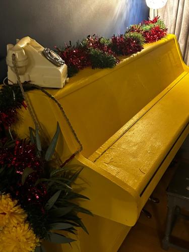 a yellow table with flowers and a purse on it at Ty Hapus Central Beaumaris in Beaumaris