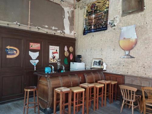 a bar with stools and a large wine glass at Grande maison familiale plein centre vieux Laval in Laval
