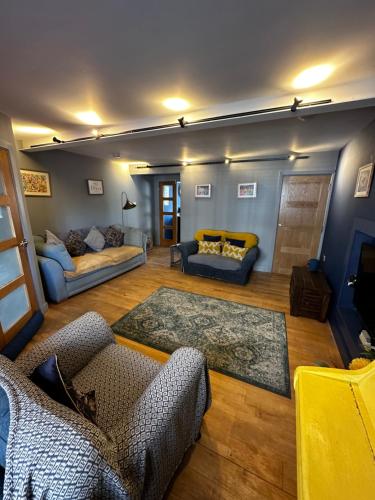 a living room with two chairs and a couch at Ty Hapus Central Beaumaris in Beaumaris