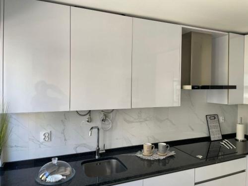 a kitchen with white cabinets and a sink at Mentor Molly in Amadora