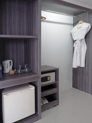 a room with a closet with a sink and a refrigerator at Pinnacle Lumpinee Park Hotel in Bangkok