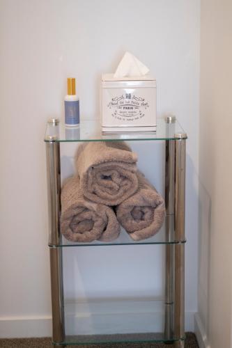a glass shelf with towels and a box on it at Modern, Ground floor , CBD, Free parking, 2-3 Beds in Christchurch