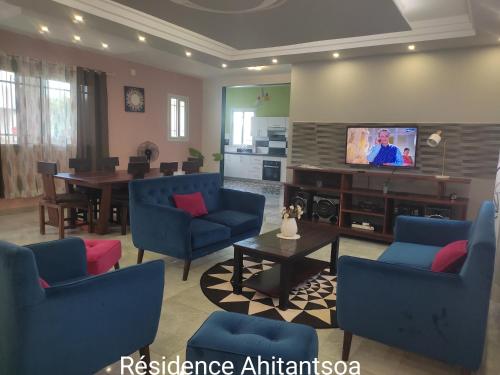 a living room with blue chairs and a television at Résidence Ahitantsoa Majunga in Mahajanga