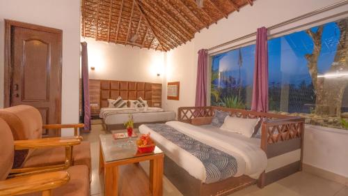 1 dormitorio con 2 camas y ventana en Corbett Fun Resort en Rāmnagar