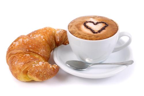 une tasse de café et un croissant sur une assiette dans l'établissement B&B La Chiave, à Vietri