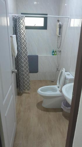 Baño blanco con aseo y lavamanos en Rimnim Hostel, en Chiang Mai
